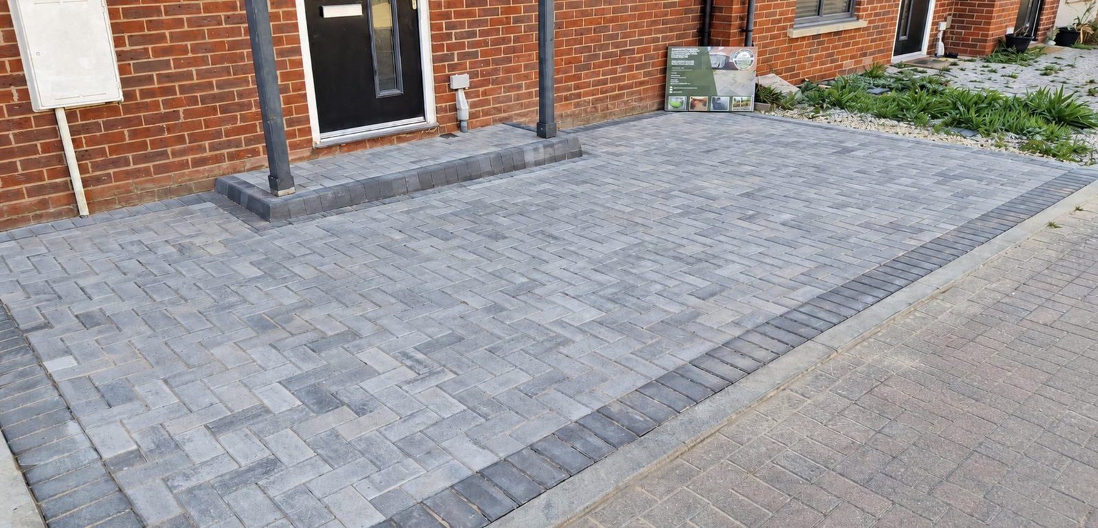 New grey herringbone block paving driveway with a charcoal border and raised front step by Lawn Ranger Landscapes, Kent