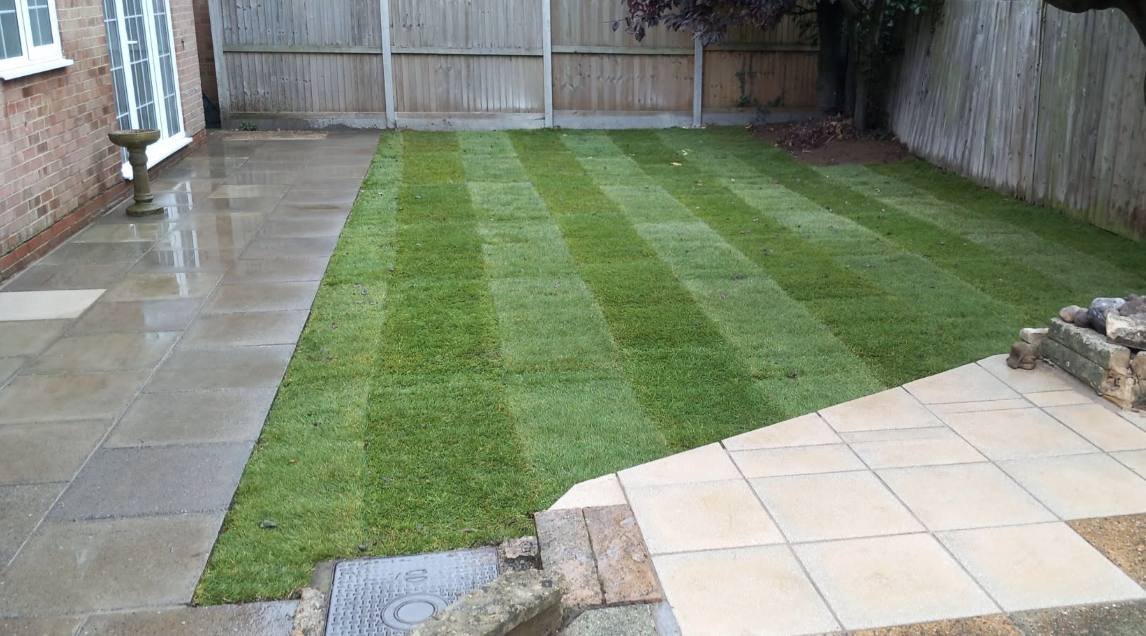 Light porcelain patio with steps and striped lawn, Kent