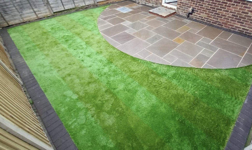 Finished circular sandstone patio with new lawn by Lawn Ranger Landscapes