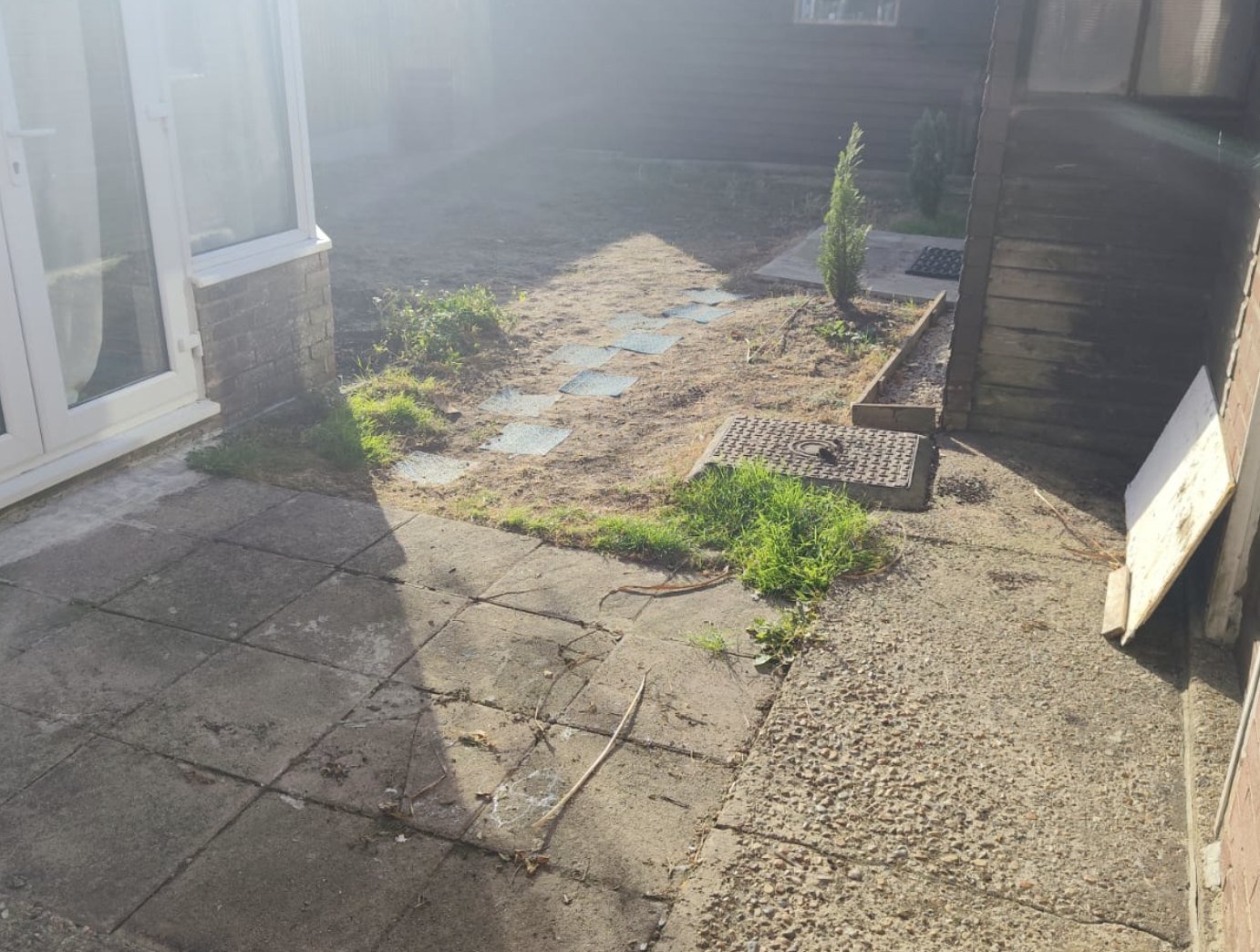 Old worn concrete patio and dead patchy ground before the garden transformation in Lydd, Kent