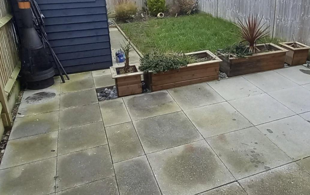 Old worn slabs and patchy ground before a new patio, Kent